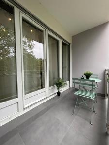 a balcony with a table and a chair on it at MoonGreen - EuroAirport - Basel - HighQuality in Saint-Louis