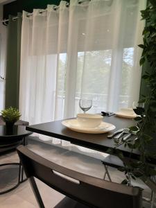 a table with a wine glass on it in front of a window at MoonGreen - EuroAirport - Basel - HighQuality in Saint-Louis