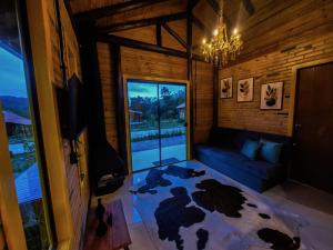 a living room with a couch and a chandelier at Cabanas Vista da Pedra in Grão Pará