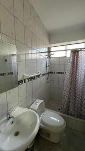 a white bathroom with a sink and a toilet at Hostal Bali - Talara in Talara