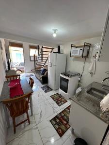 a kitchen with a stove and a refrigerator and a table at A casa roxinha in Lençóis