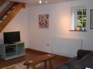 a living room with a couch and a tv at Bluebell and Appletree Cottages in Hockwold cum Wilton