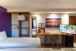 a bedroom with a bed and a desk with a computer at Mundy Arms Hotel Derby in Derby
