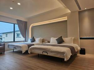 two beds in a room with a large window at Mysig Villa in Ch'eng-kung-li