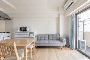 a living room with a table and a couch at Jintai House201 in Fukuoka