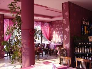 un ristorante con pareti e tavoli rosa e sedie di Hotel Amfibia a Primorsko