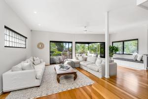 a living room with white furniture and large windows at Luxurious Beachside Oasis with Ocean Views in Gold Coast