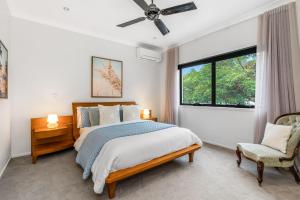 a bedroom with a bed and a window and a chair at Luxurious Beachside Oasis with Ocean Views in Gold Coast +10 photos