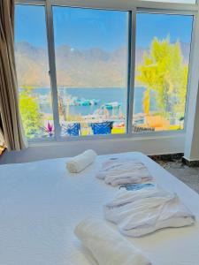 a bed with white towels on it with a window at TIBERIAS by luxury Atitlan in San Pedro La Laguna