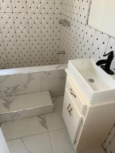 a white bathroom with a sink and a bath tub at VIP Hotel Haiti in Port-de-Paix