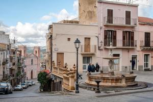 una fontana in mezzo a una strada con edifici di Hotel Pomara a San Michele di Ganzaria