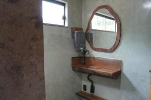 a bathroom with a wooden sink and a mirror at Recanto dos Licuris in Lençóis