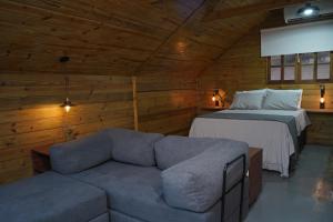 a living room with a couch and a bed in a cabin at Recanto dos Licuris in Lençóis