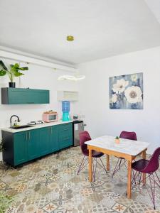 a kitchen with green cabinets and a table and chairs at TIBERIAS by luxury Atitlan in San Pedro La Laguna