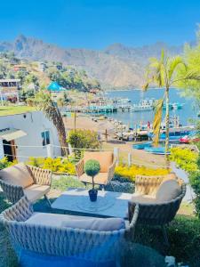 a patio with a table and chairs and a beach at TIBERIAS by luxury Atitlan in San Pedro La Laguna