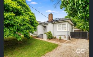 a white house with a brick chimney on top at Wollemi Cottage Orange in Orange