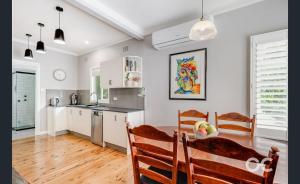 a kitchen and dining room with a table and chairs at Wollemi Cottage Orange in Orange