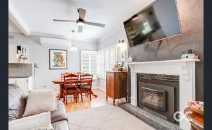 a living room with a fireplace with a tv above it at Wollemi Cottage Orange in Orange