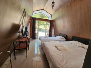 a room with two beds and a tv and a window at Bromo Camp House in Bromo +82 photos