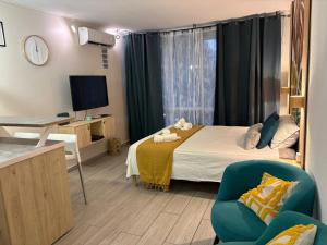 a room with a bed and a chair and a television at Studio en bord de mer - létama - Résidence Archipel Savane in Le Gosier