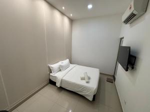 a small room with a bed and a tv at One Point Hotel @ Airport (Kuching) in Kuching