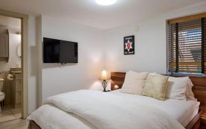 a bedroom with a bed and a television on the wall at 3 bdrm cottage in Predeal in Predeluţ