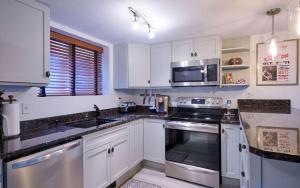 a kitchen with white cabinets and stainless steel appliances at 3 bdrm cottage in Predeal in Predeluţ +1 photo