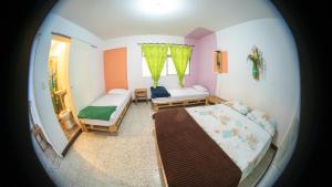 a small bedroom with a bed and a window at Hostal Paz y Vida in Medellín