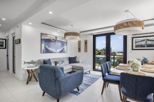 a living room with a couch and chairs and a table at Casa Blue Laguna II |"Tropical Escape with Ocean Views I Steps to Bio Bay & Seven Seas I Guest Discounts on Boat Tours" in Fajardo +95 photos