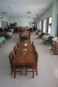a dining room with wooden tables and chairs at Phafan pool villa in Ban Pa Sang (1)