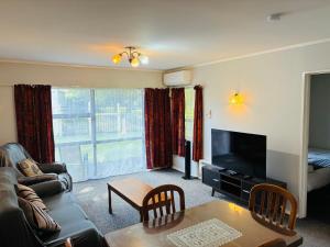 a living room with a couch and a television at Awatea Park Motel in Palmerston North