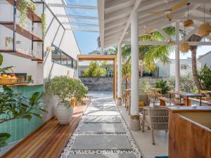 a restaurant with a patio with tables and plants at Biosphere Beach in Dharavandhoo