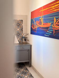 a room with a painting of a boat on the wall at Casa Armonia in Favignana +57 photos