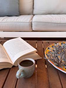 a book and a cup of coffee on a table with a plate of food at Casa Armonia in Favignana