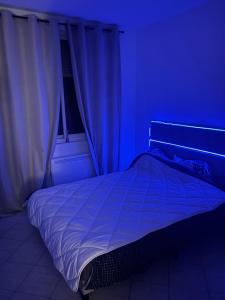 a bedroom with a bed with a blue light at Logement catalan in Perpignan