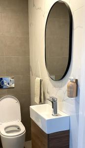 a bathroom with a white toilet and a mirror at Lakeside Breeze in Jindabyne +18 photos
