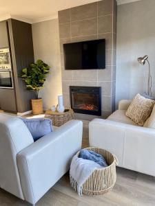 a living room with a couch and a fireplace at Lakeside Breeze in Jindabyne