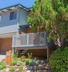 a house with a deck on the side of it at Lakeside Breeze in Jindabyne