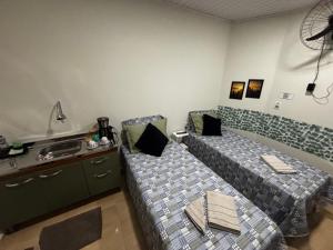 a room with two beds and a sink in it at Rancho do Viajante Quarto B2 in Castro +3 photos