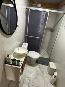 a bathroom with a toilet and a sink and a mirror at Rancho do Viajante Quarto B2 in Castro