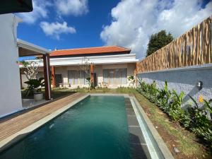 a swimming pool in front of a house at Ramaiin guest house in Nusa Dua