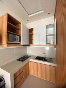 a kitchen with a sink and a microwave at Ramaiin guest house in Nusa Dua