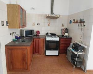 a small kitchen with a stove and a microwave at Vallesito in Salsipuedes