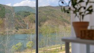 a window with a view of a river and mountains at Chuncheon The Van Pool Villa in Chuncheon