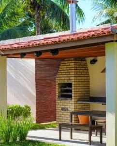 a patio with a bench under a roof at Condomínio Diver in Vera Cruz de Itaparica