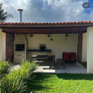 a patio with a roof and a table and chairs at Condomínio Diver in Vera Cruz de Itaparica