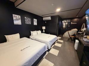 a hotel room with two beds and a kitchen at Dalbit Sori Hotel Jeonju in Jeonju