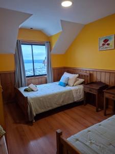 a bedroom with two beds and a window at Vista volcanes house in Puerto Varas