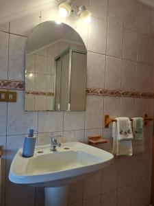 a bathroom with a sink and a mirror and towels at Vista volcanes house in Puerto Varas