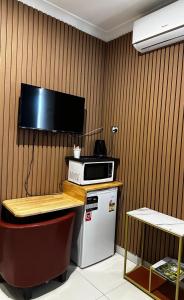 a kitchen with a microwave and a tv on a wall at Perth City Motel in Perth